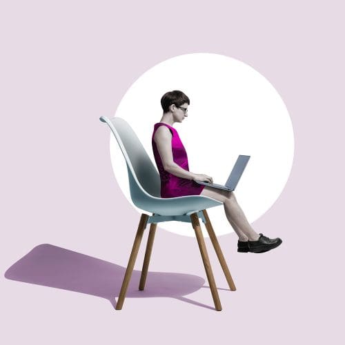 Side view of a woman sitting on an oversized office chair using a laptop, set against a solid pale purple background.